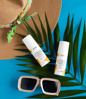 Αντηλιακά προϊόντα με SPF 50 σε καλοκαιρινή διακόσμηση.